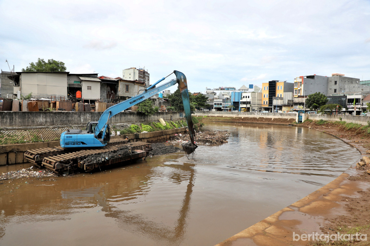 Satu alat berat sedang mengeruk lumpur Kali Ciliwung