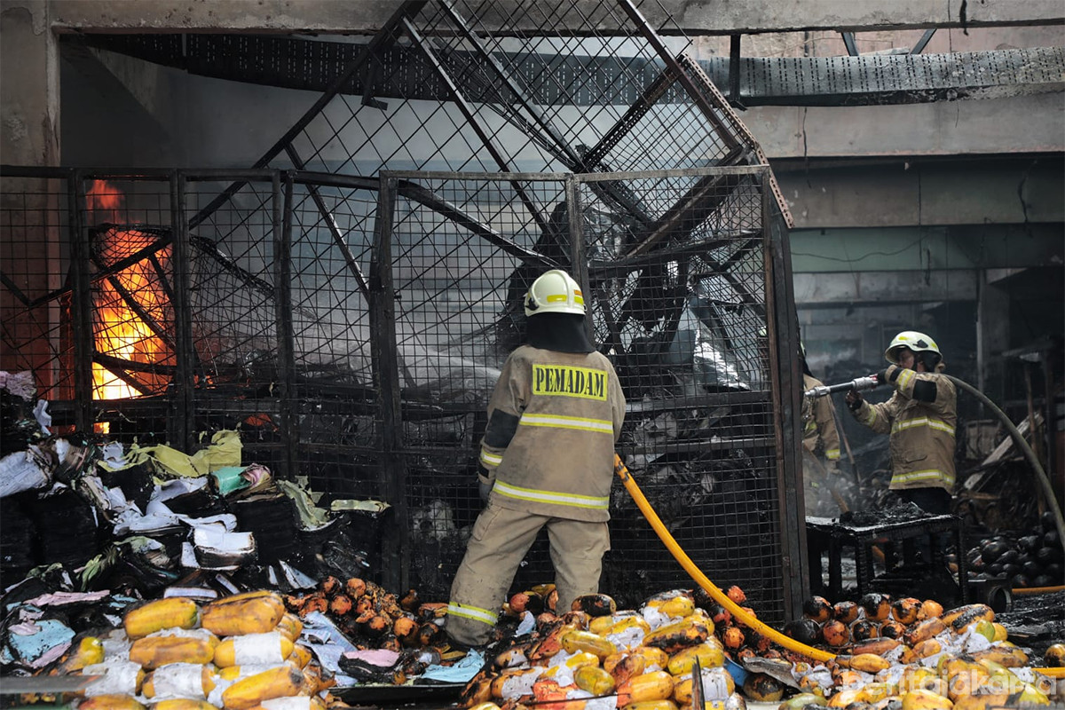 Petugas memadamkan api yang melahap ratusan kios di PasarInduk Kramat Jati, Senin (15/12)
