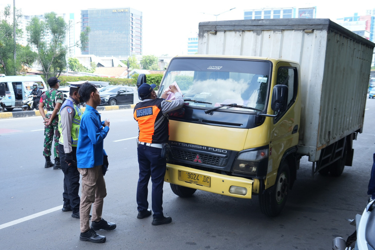 Petugas memberikan sanksi tilang pada kendaraan yang melanggar aturan di wilayah Jaktim