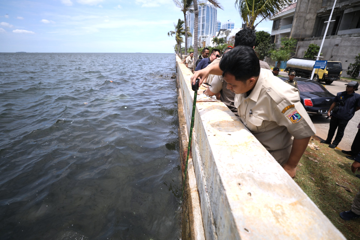 Petugas melakukan pengukuran untuk perbaikan tanggul Pantai Mutiara