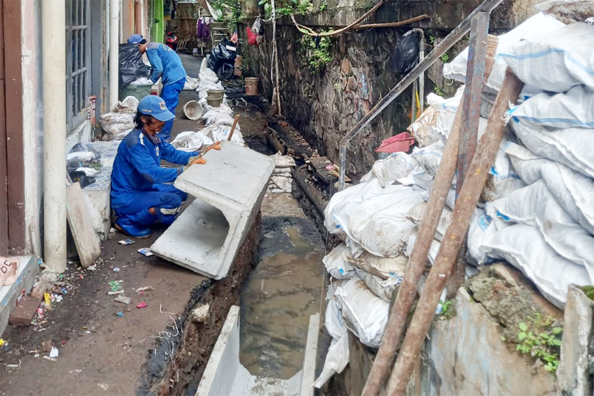 Personel Satpel SDA Kecamatan Jatinegara membuat saluran air di Bidara Cina