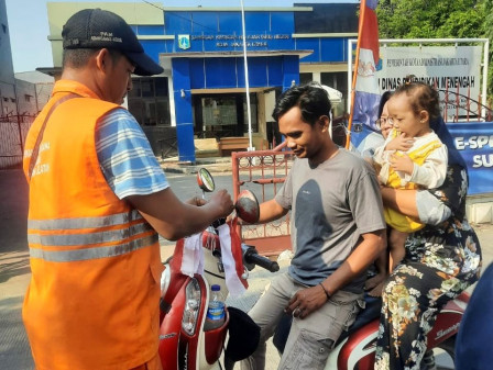 Kelurahan Tugu Selatan Bagikan Bendera Merah Putih ke Warga