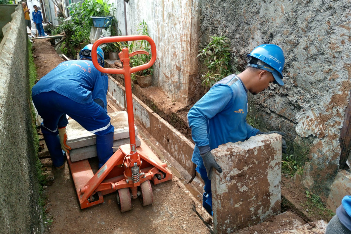 Proses pemasangan tutup beton pada saluran air Masjid Baiturrohmah Gang Pos 1