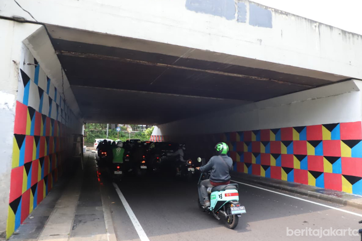 Pengendara motor melintas di bawah Kolong Semanggi yang dipercantik dengan mural