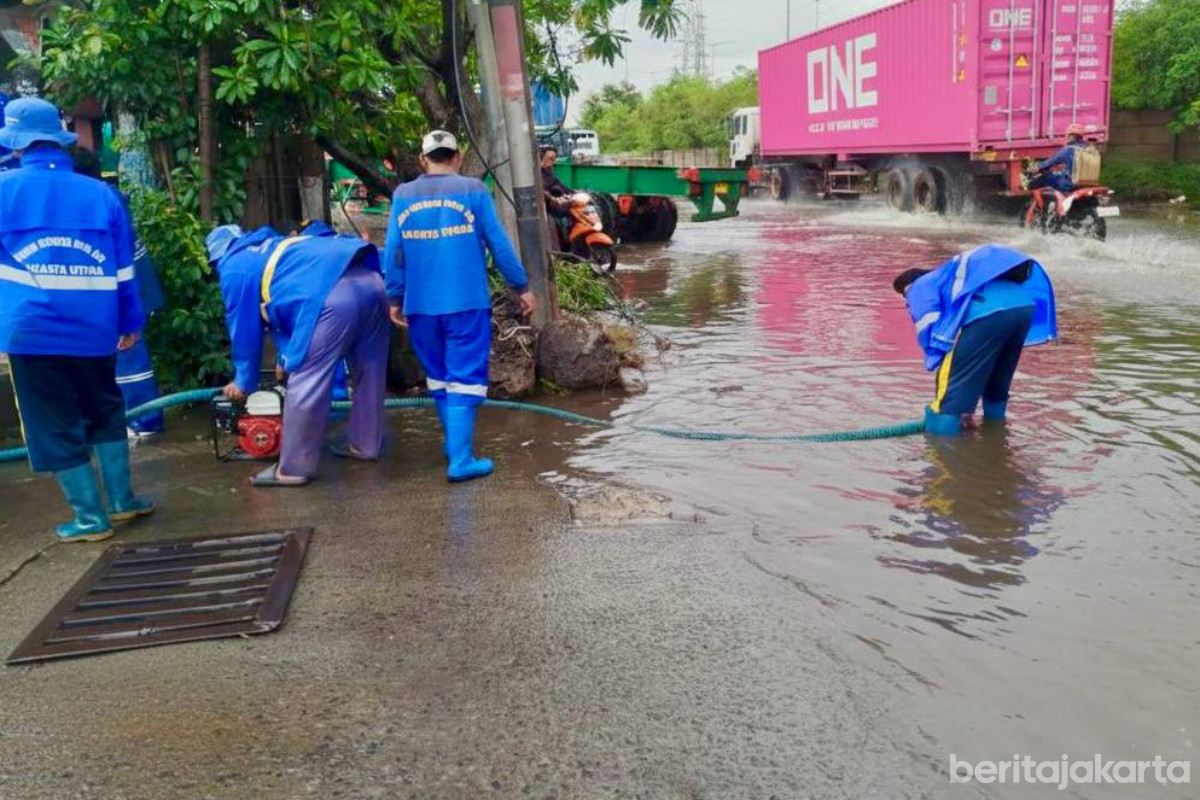 Sejumlah petugas melakukan penanganan genangan di Cilincing
