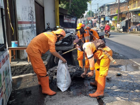 10 Petugas PPSU Bersihkan Saluran di Jalan Kapuk Pospol
