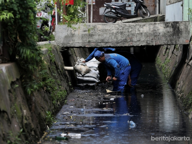 Sejumlah Petugas melakukan pengurasan saluran Phb Menteng Pulo