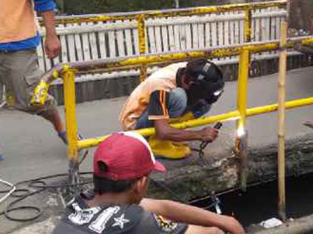 Petugas PPSU Perbaiki Pagar Jembatan Kali Betik