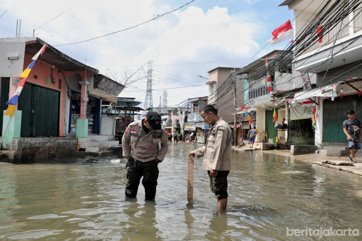 Petugas BPBD DKI sedang mengukur ketinggian banjir rob