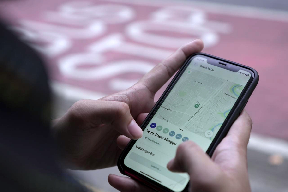 Penumpang transjakarta sedang menggunakan fitur AI Assistant dan Companion Mode