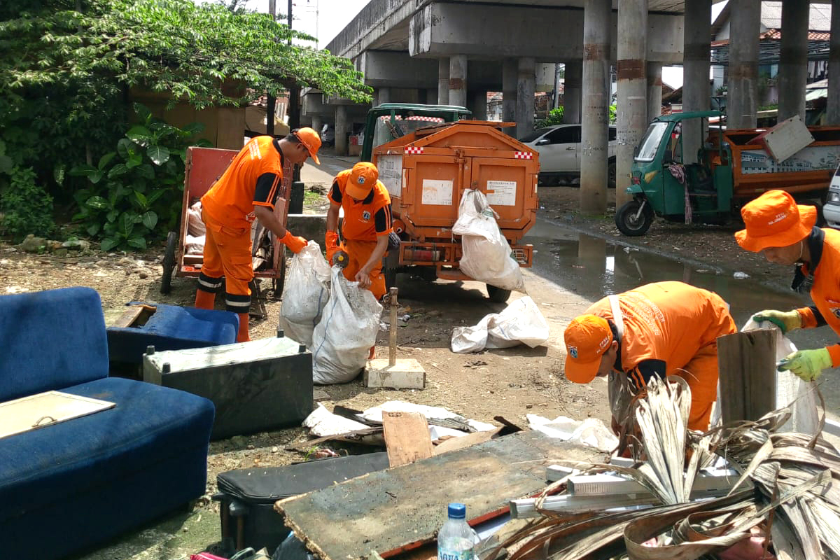 Petugas melakukan pengangkutan sampah sisa genangan di Kramat Jati