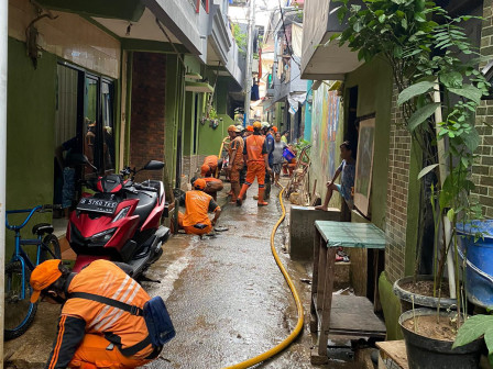 Personel Gabungan Bersihkan Lumpur Sisa Banjir di Kampung Melayu 