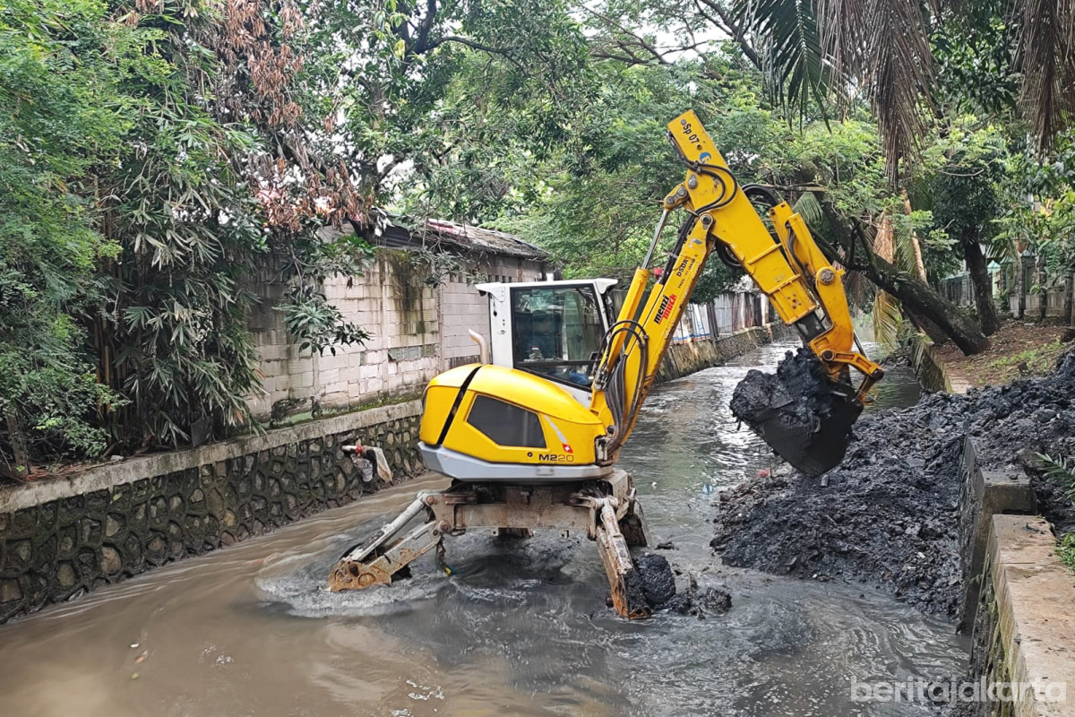 Satu unit ekskavator melakukan pengerukan saluran penghubung Pulo di Jalan Raya Pasar Minggu