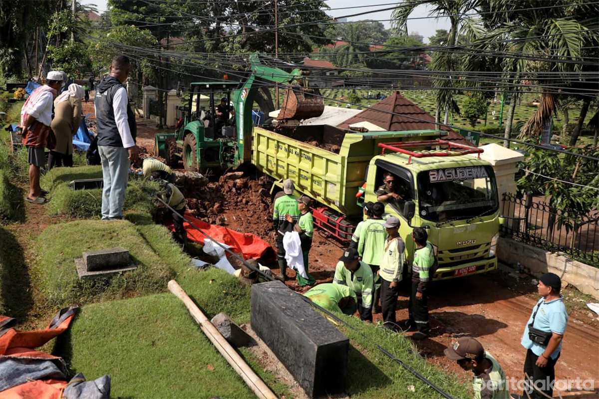 Petugas melakukan penanganan tembok TPU Jeruk Purut yang longsor