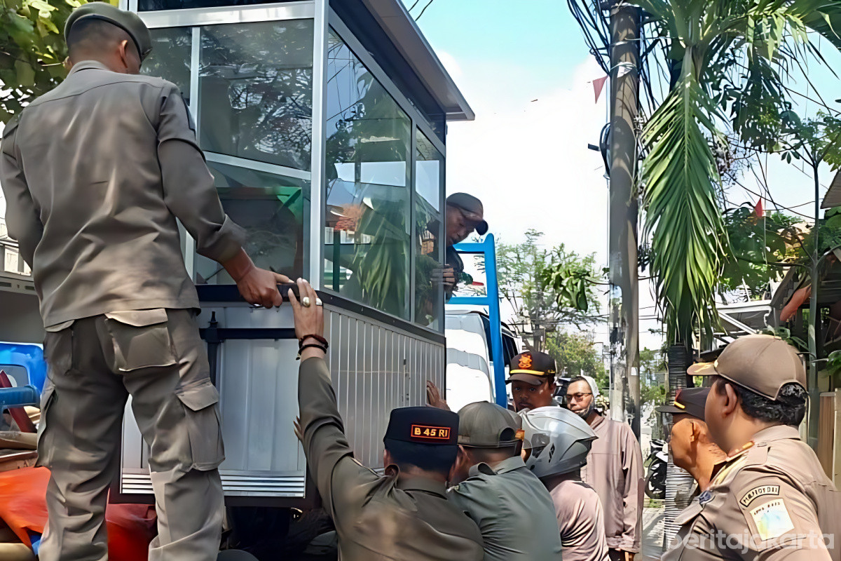 Petugas mengamankan gerobak PKL di atas trotoar Jalan Raya Bugis