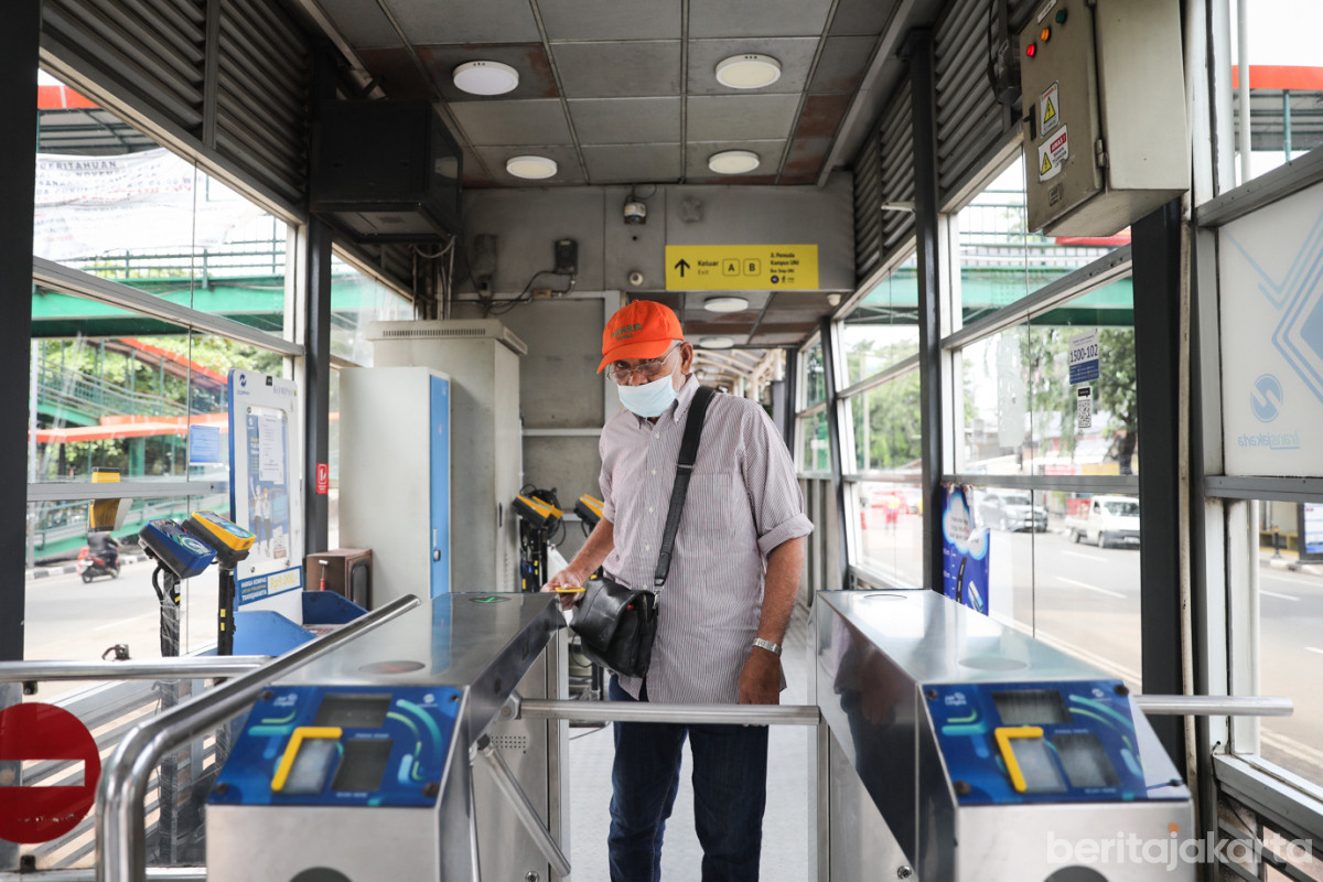 Seorang penumpang melakukan tap in di Halte Transjakarta Rawamangun