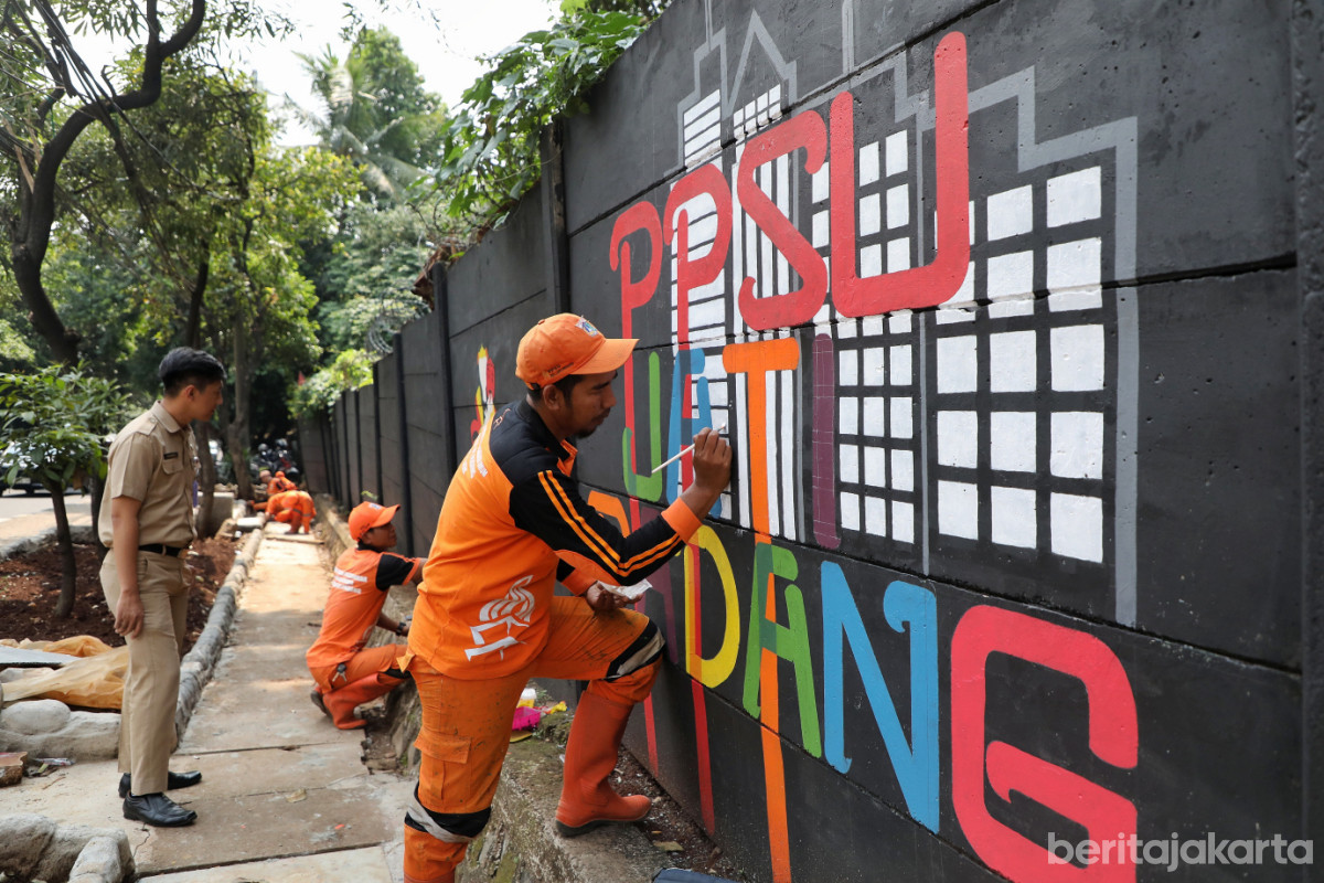 Petugas PPSU Jati Padang sedang menyelesaikan pembuatan mural