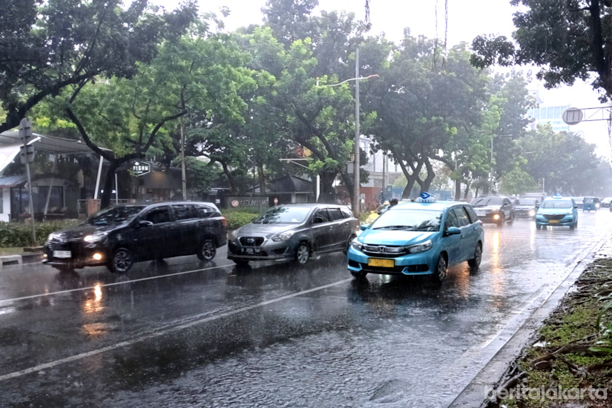 Sejumlah kendaraan melintas saat cuaca hujan di penghujung tahun 2025