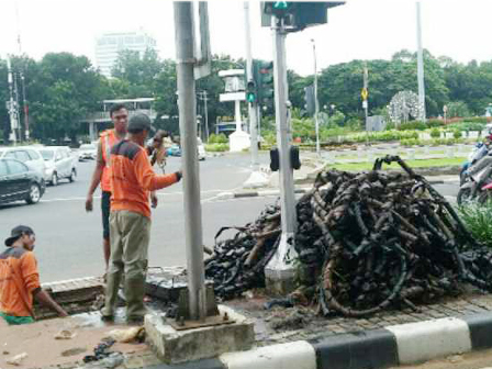 Kulit Kabel Dibersihkan dari Saluran Jl Medan Merdeka Selatan