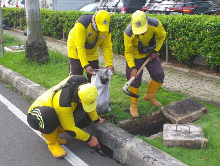 Petugas Bina Marga Bersihkan Tali Air di Jalan Raya Ring Road 
