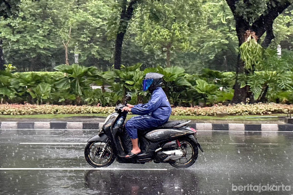 Seorang Pengendara motor melintas saat cuaca hujan