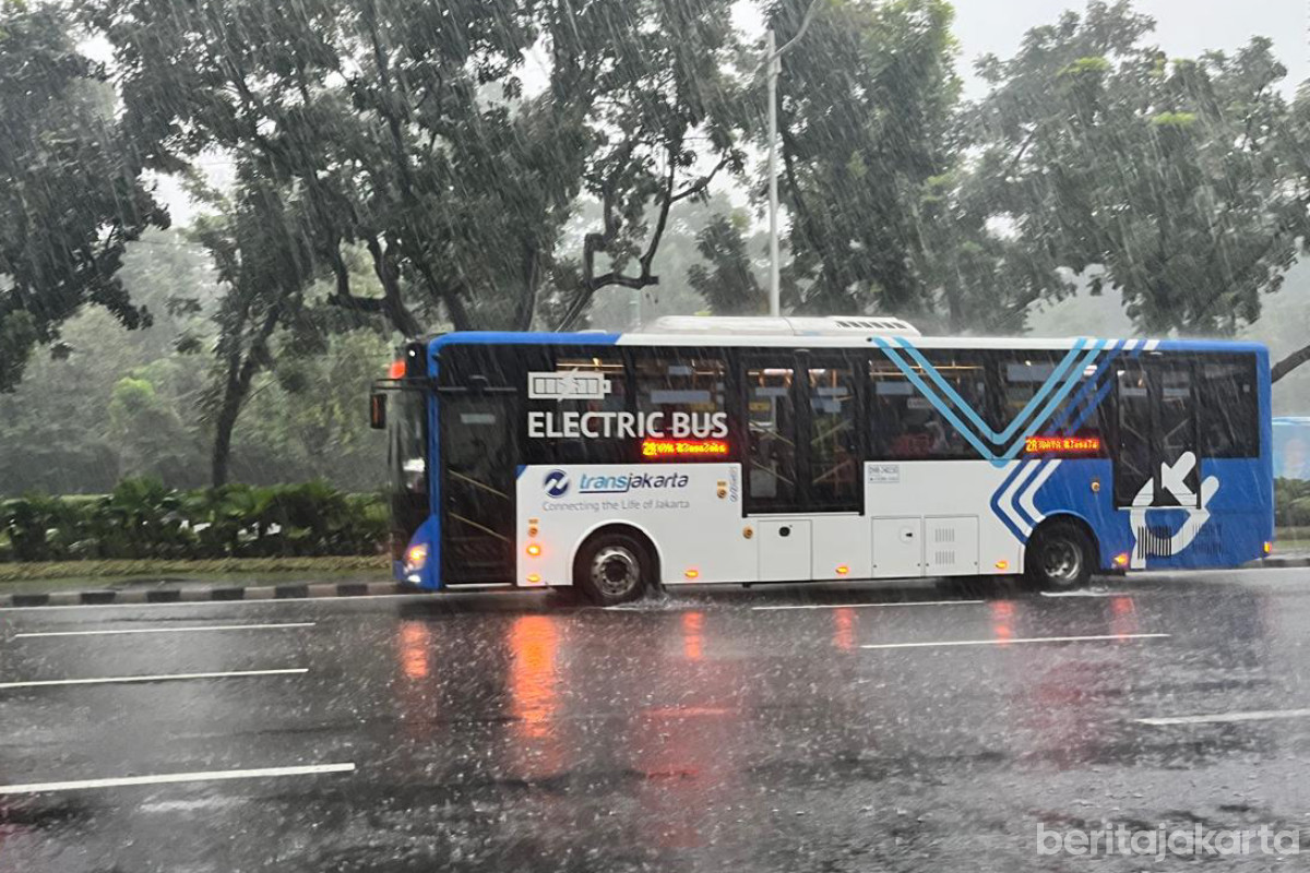 Bus transjakarta melintas jalanan Jakarta saat cuaca hujan