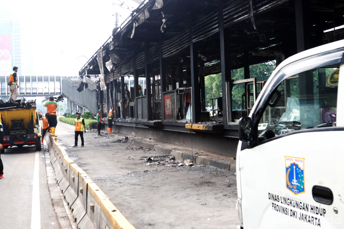 Petugas Dinas LH DKI Jakarta membersihkan Halte Polda yang terbakar