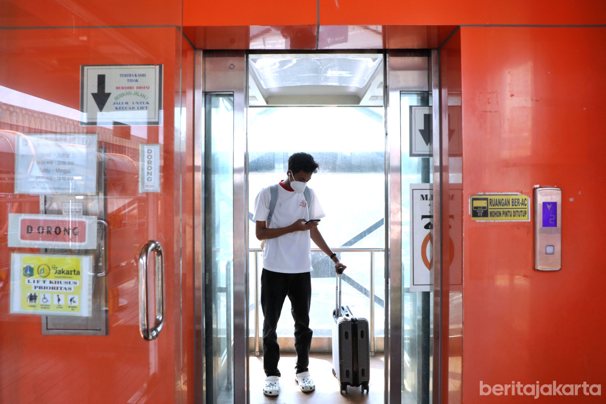 Seorang warga sedang menggunakan Lift Skywalk Kebayoran Lama yang kembali beroperasi