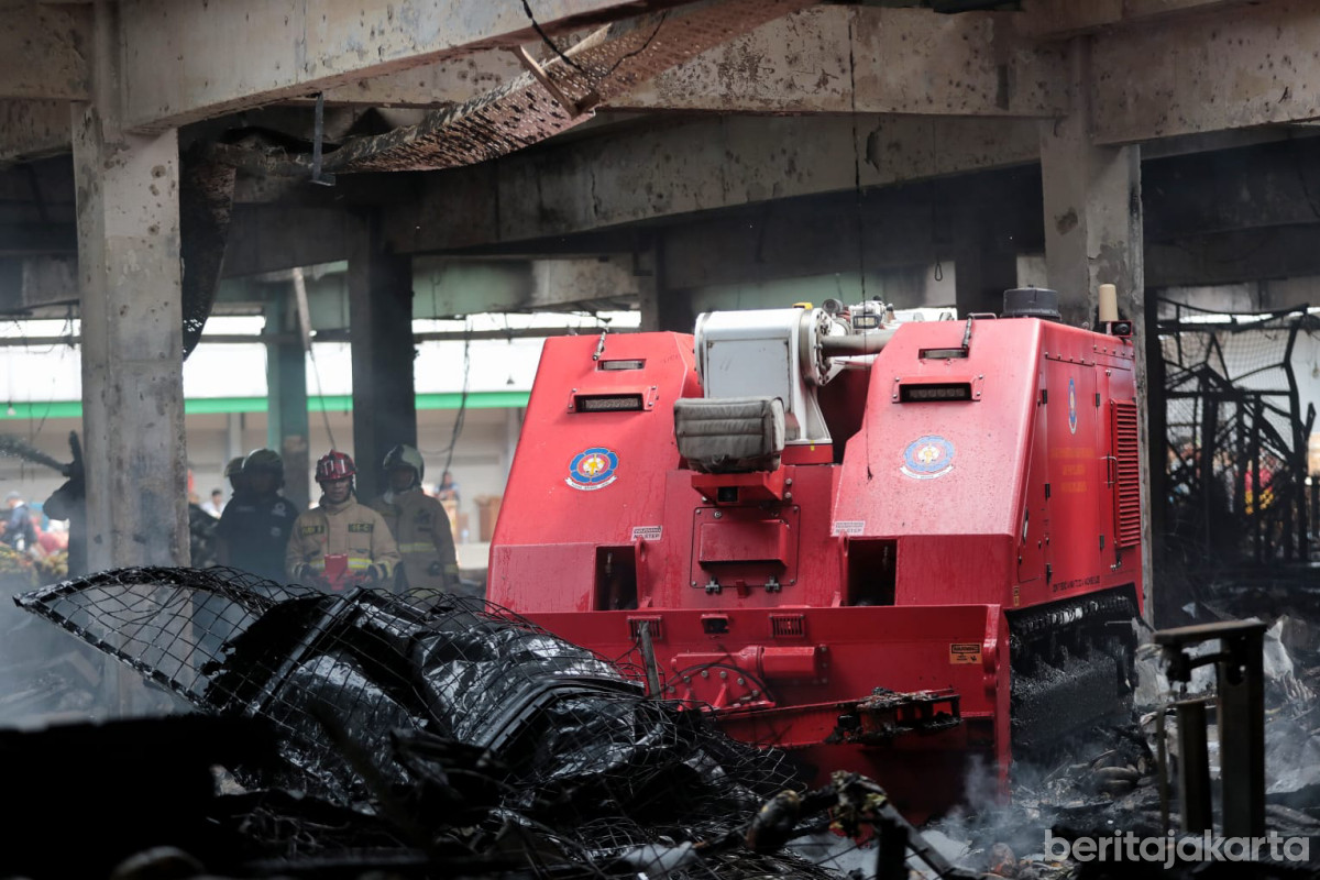 Petugas menggunakan robot pemadam untuk menangani kebakaran di Pasar Induk Kramat Jati