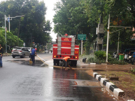 Petugas Bersihkan Ceceran Tanah di Jalan Kebon Sirih 