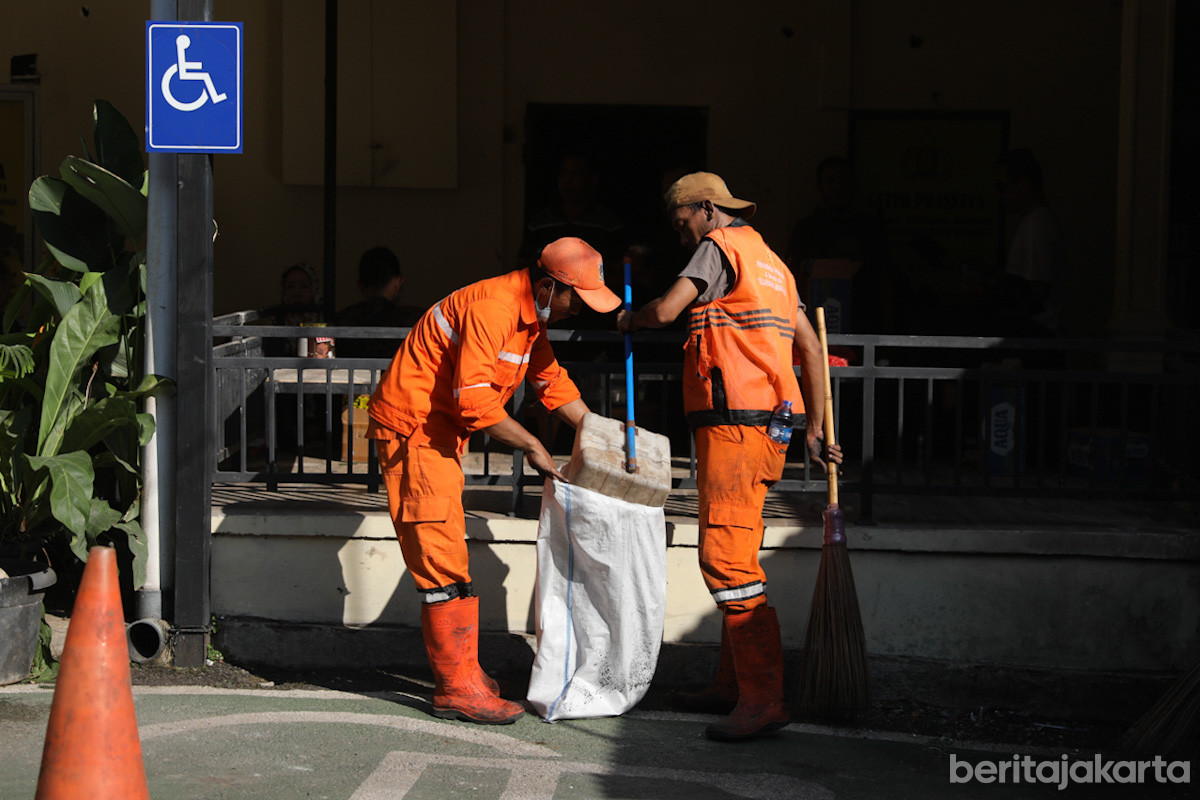 Petugas PPSU mengangkut sampah