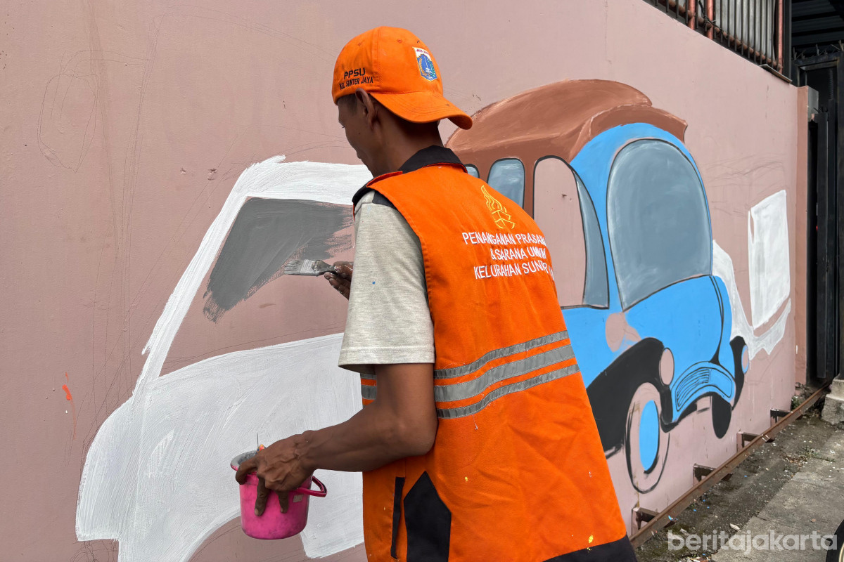 Petugas PPSU Kelurahan Sunter Jaya membuat mural di Jalan Krida Nirmala