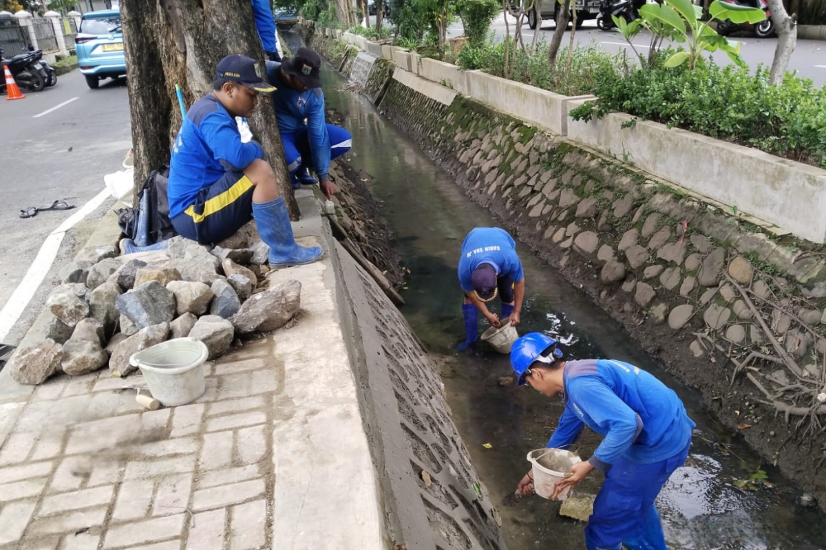Sejumlah petugas melakukan perbaikan turap saluran air di Jalan Kelapa Cengkir Raya