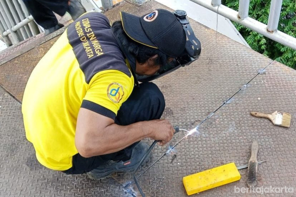 Petugas memperbaiki plat besi di JPO Sahabat Daan Mogot