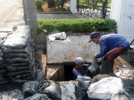  Puluhan Pasukan Biru Kuras Saluran Air di Perempatan Jalan Meruya Selatan 