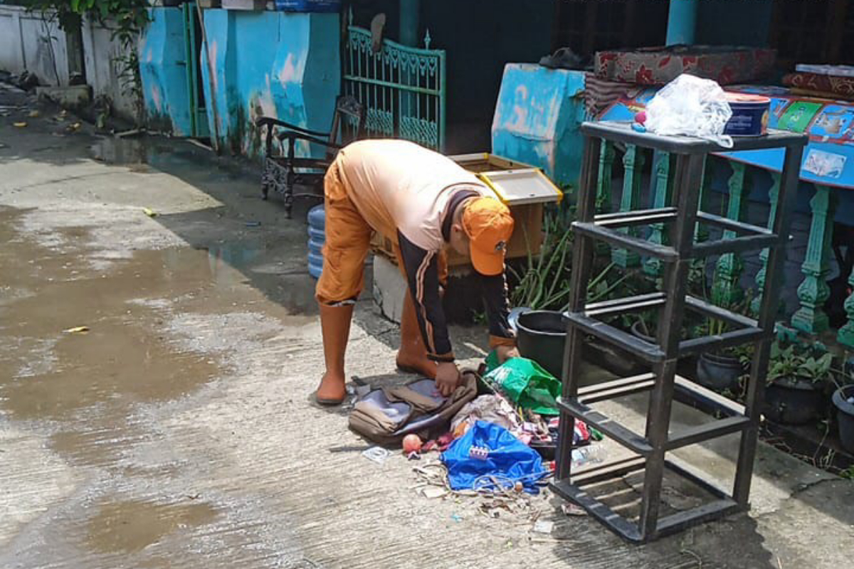Petugas PPSU membantu membersihkan rumah warga pasca Genangan di Cakung Barat