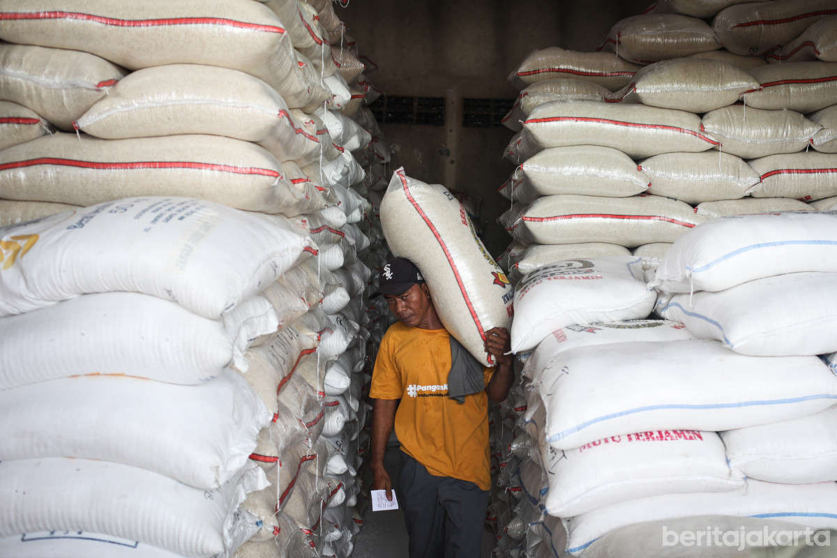 Seorang pekerja sedang mengangkut beras di Pasar Induk Beras Cipinang