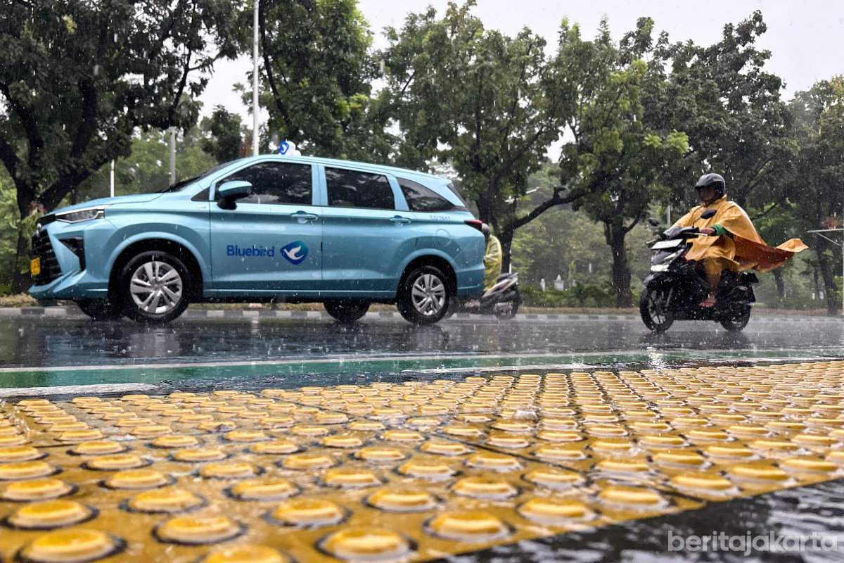 Sejumlah kendaraan melintasi jalan saat hujan