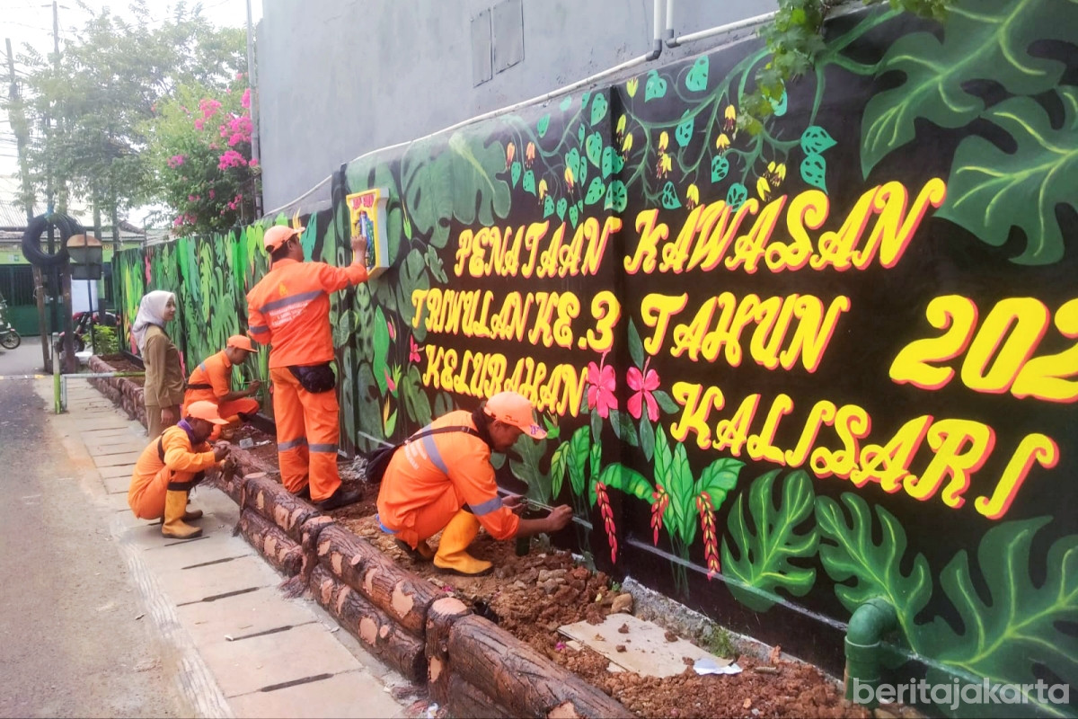 Petugas PPSU sedang menyelesaikan pembuatan mural