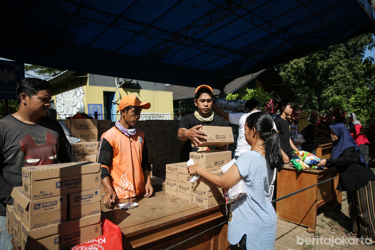 Petugas PPSU sedang membantu pendistribusian susu UHT