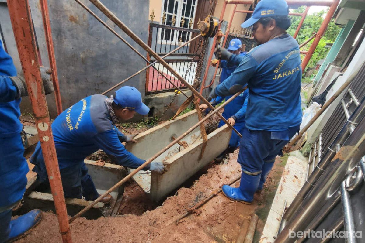 Sejumlah petugas melakukan pemasangan beton U-ditch pada saluran air di Jl TPU Munjul