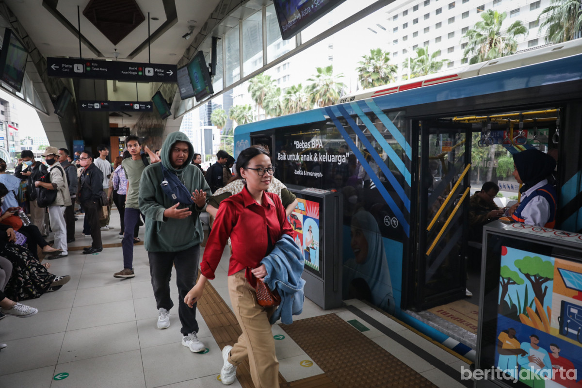 Sejumlah penumpang saat akan masuk ke dalam bus Transjakarta