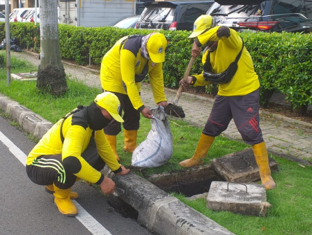 Petugas Bina Marga Bersihkan Tali Air di Jalan Satu Maret