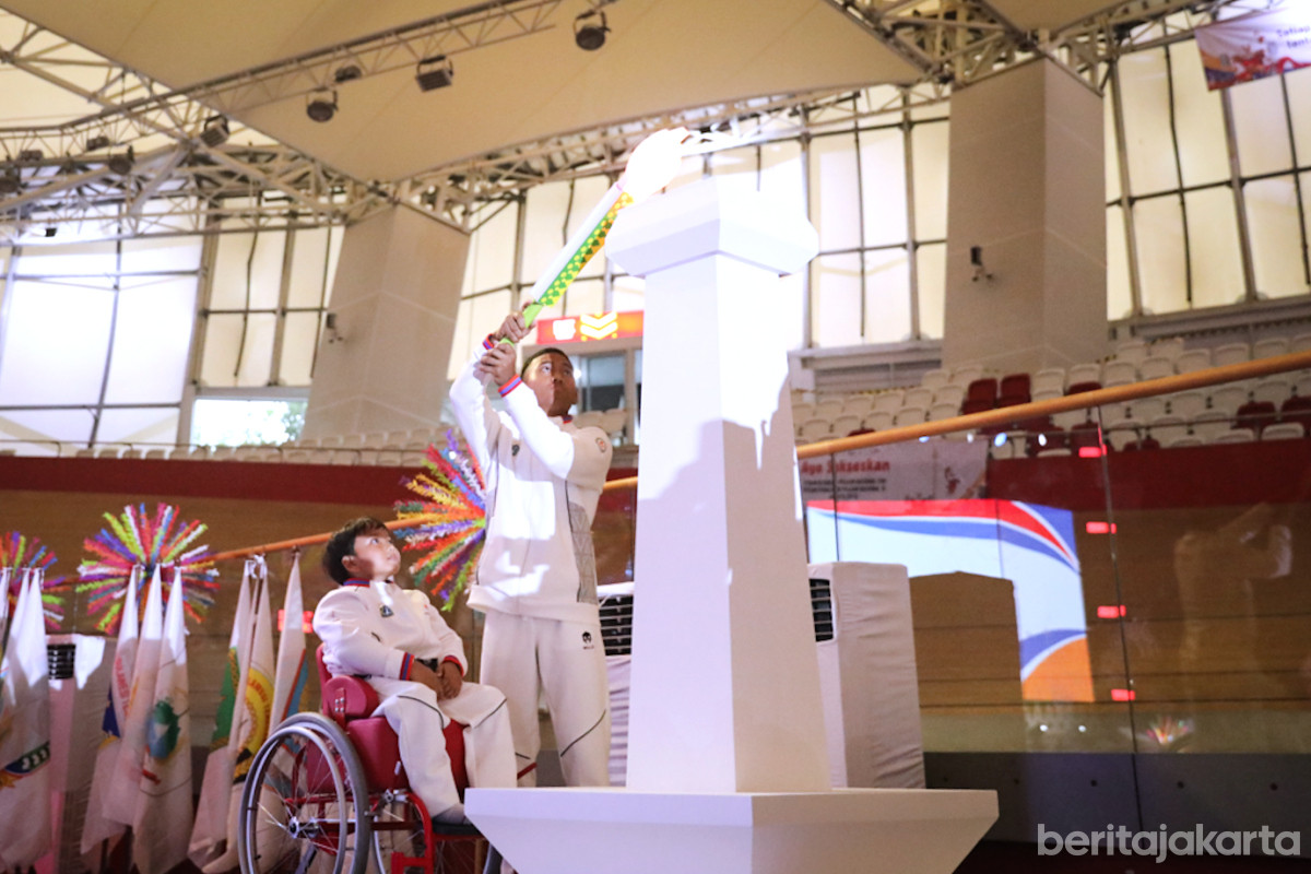 Perwakilan atlet POPNAS dan PEPARPENAS menyalakan kaldron berbentuk Monas