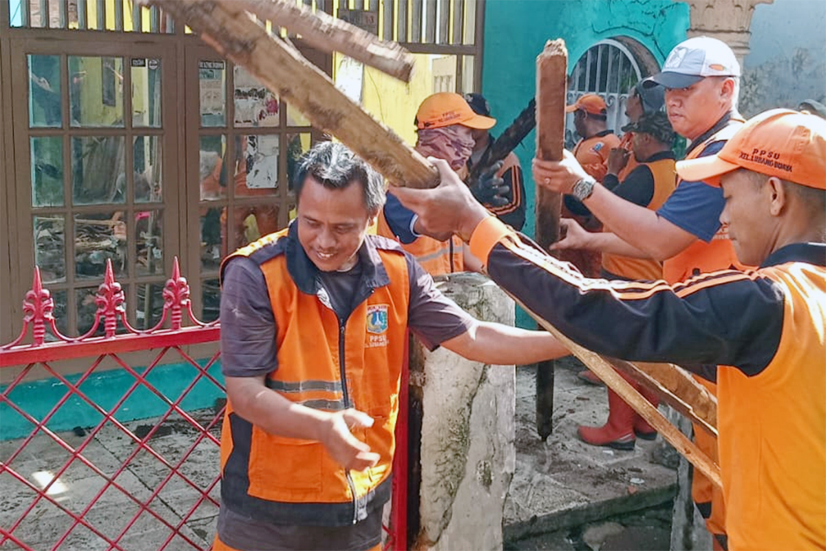 Petugas PPSU bahu membahu bersihkan material atap rumah ambruk di Lubang Buaya