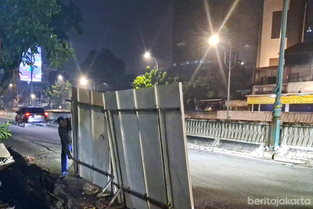 Petugas menutup sementara saluran air terbuka di Jalan Terusan Haji Rasuna Said