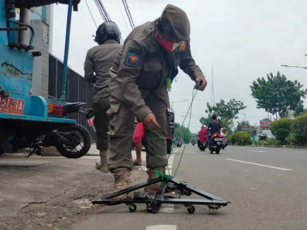 Satpol PP Bersihkan Paku di Jalan Joglo Raya