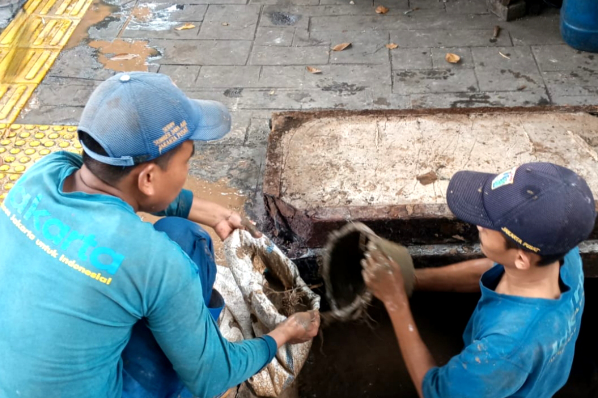 Petugas melakukan pengurasan Saluran Air di Jalan P Jayakarta