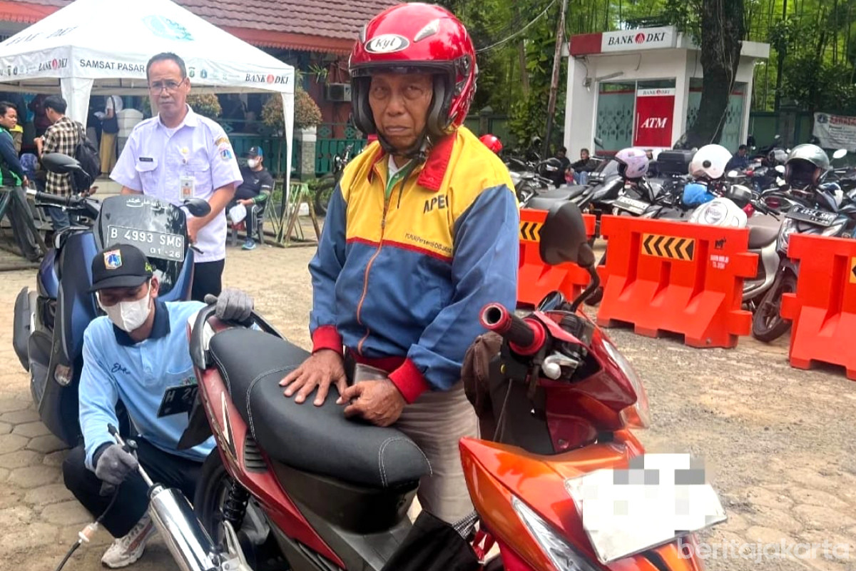 Petugas melakukan uji emosi pada kendaraan roda dua di Pasar Minggu