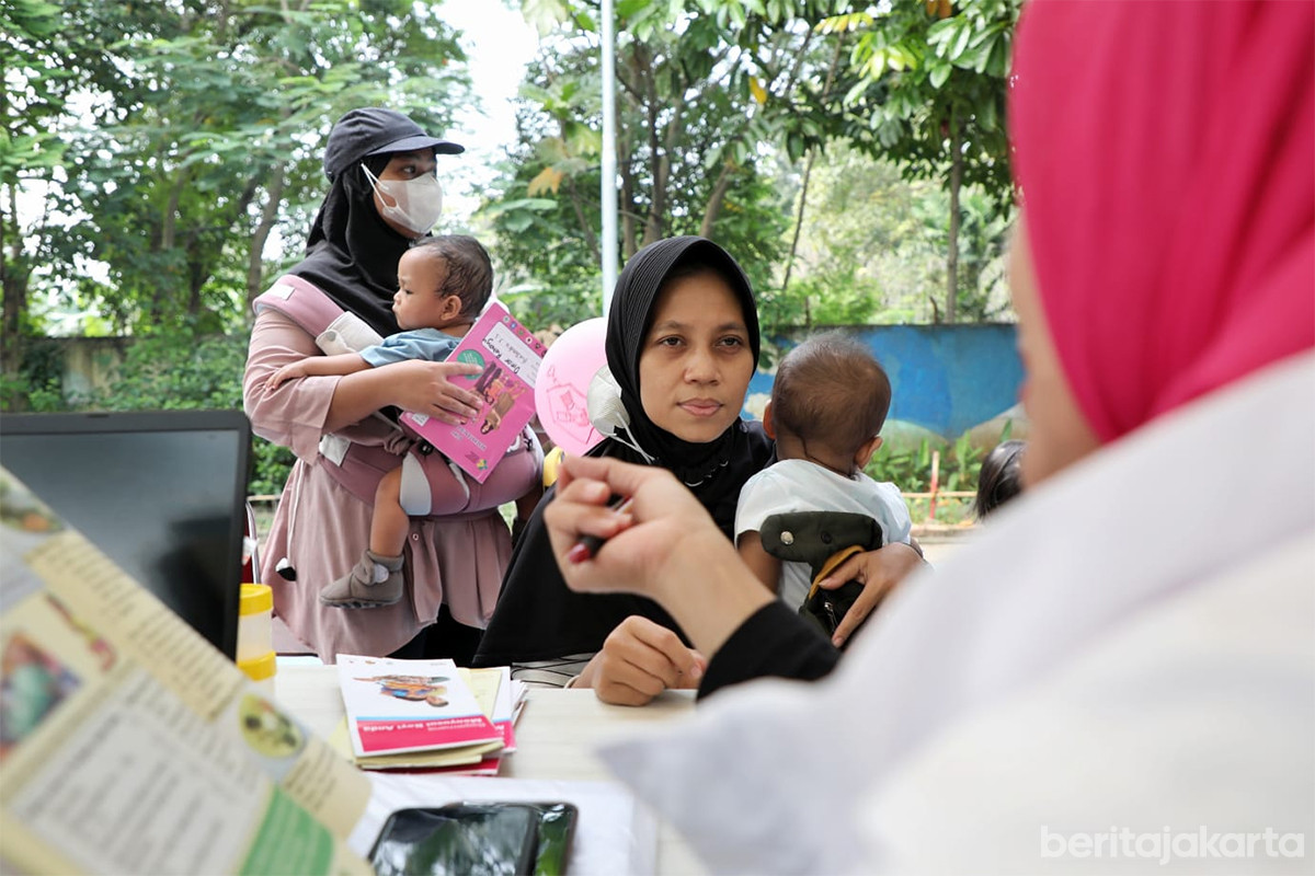 Seorang ibu memeriksakan kesehatan anaknya di posyandu